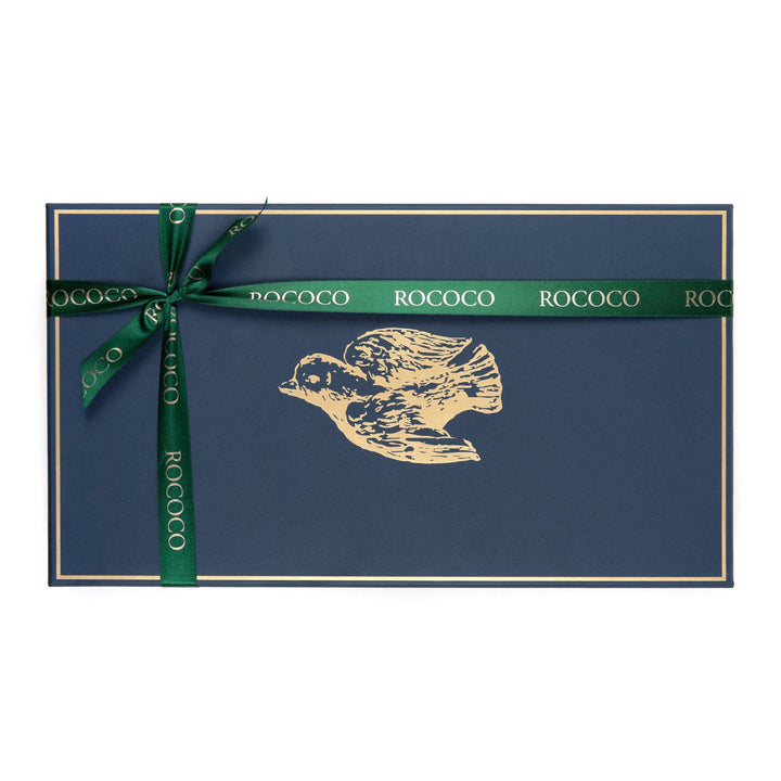 Luxurious 'A Celebration of Truffles' by Rococo Chocolates, ideal Eid gift, with 91 handcrafted truffles in white, milk, dark, and sea salt caramel. Crafted with precision in London, these non-alcoholic, inclusive truffles are a symbol of celebration. Elegantly boxed in navy with a gold Dove, and forest green rococo ribbon, it epitomizes the joy and luxury of Eid celebrations.